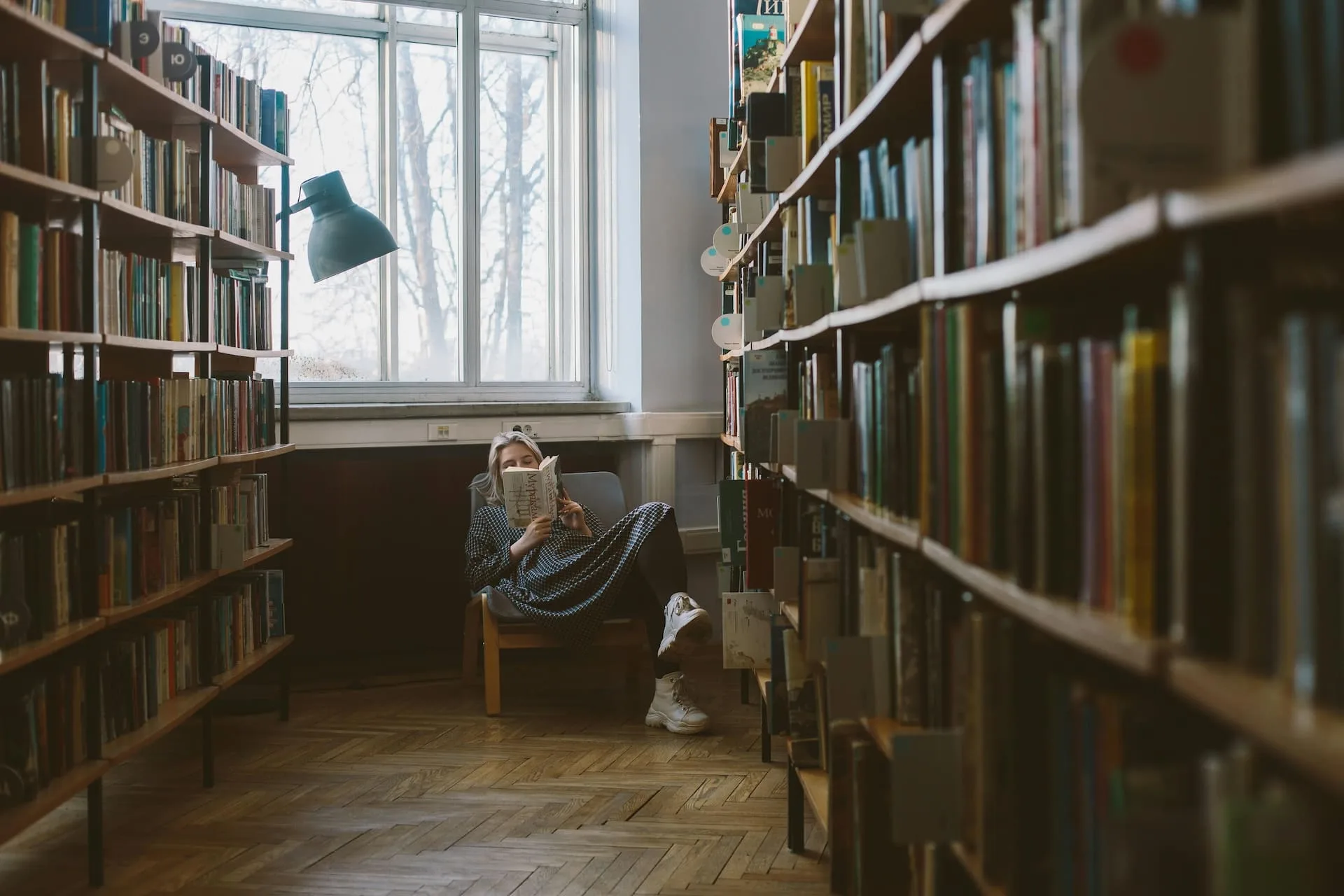 Mujer sentada en sillon dentro de biblioteca de el jardin leyendo libros de superacion personal autoayuda emprendimientos estoicismo soy maryce