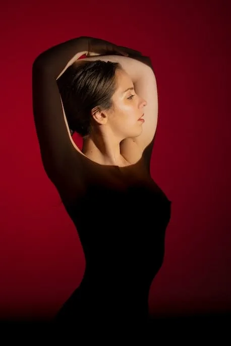 woman-front-red-background iluminada con luz directa en rostro soy maryce